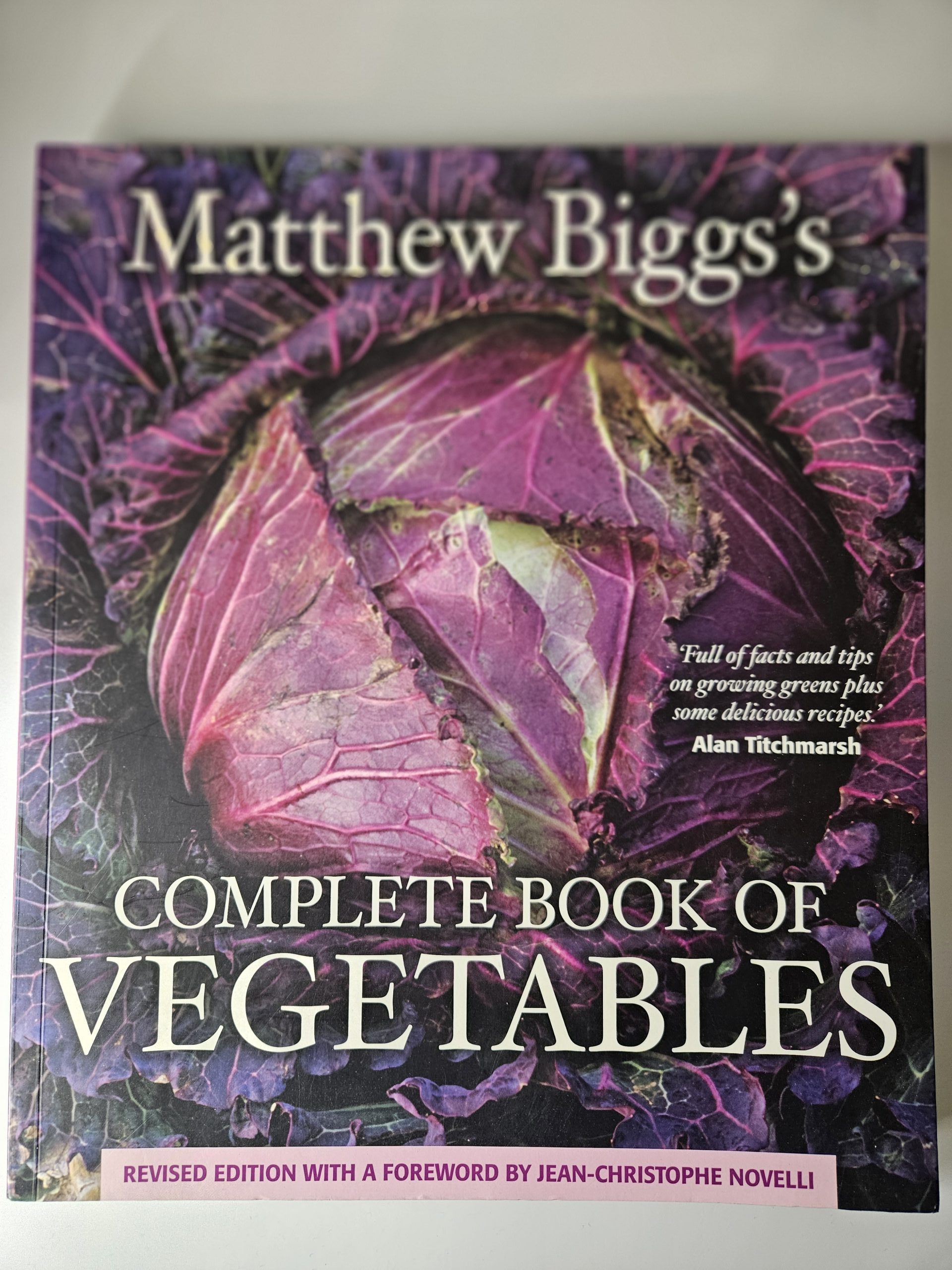 Purple floral book cover with large white vertical title text and pink foreword spine reading 'Revised Edition'